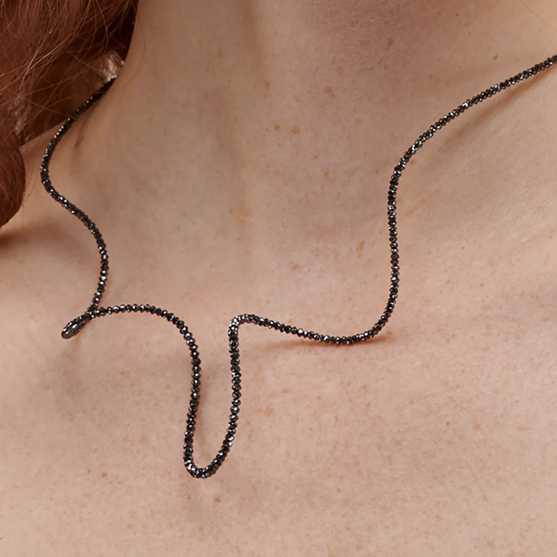 Close up image of the Spiral Necklace with Black Diamonds designed by Patrice Fabre worn by @lucy.w.m