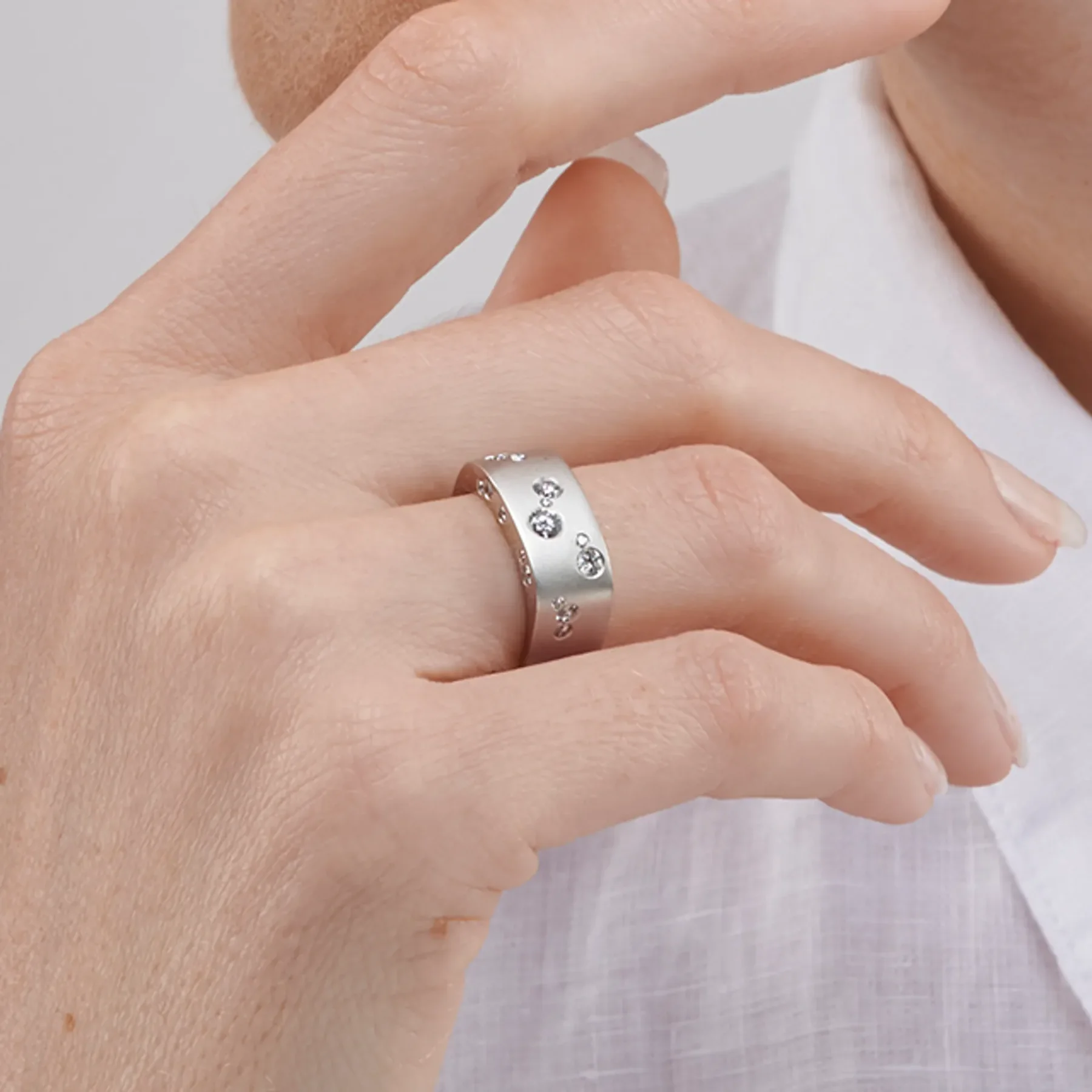 Close up image of the Ribbon Large Band White Gold Ring with Diamonds designed by Thierry Vendôme worn by @lucy.m.w